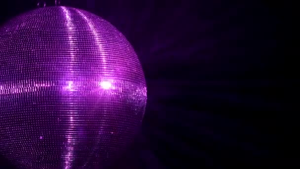 Μια καθρεφτισμένη ντίσκο μπάλα γυρίζει σε ένα πάρτι. Κόκκινες και μπλε ακτίνες φωτός αντανακλώνται από αυτό στον καπνό.. — Αρχείο Βίντεο
