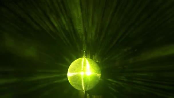 Egy tükrözött diszkógömb forog egy partin. A sárga fénysugarak visszaverődnek a füstben.. — Stock videók