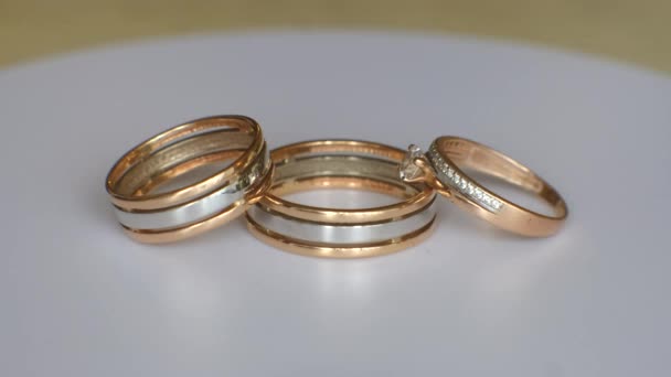 Tres Anillos Bodas Oro Platino Giran Sobre Una Mesa Blanca — Vídeos de Stock