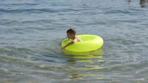 Ein Kleiner Junge Schwimmt Meer Auf Einem Hellen Aufblasbaren Kreis — Stockvideo