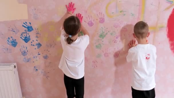 Mały Chłopiec Dziewczynka Rysujący Dłońmi Farbami Różowej Tapecie Ścianie Pokoju — Wideo stockowe