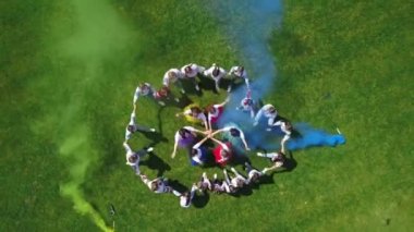 Ukrayna kostümlü okul çocukları, dünya barışı için renkli dumanlar kullanarak dans ediyorlar. Helikopterden kuş bakışı görüntü..