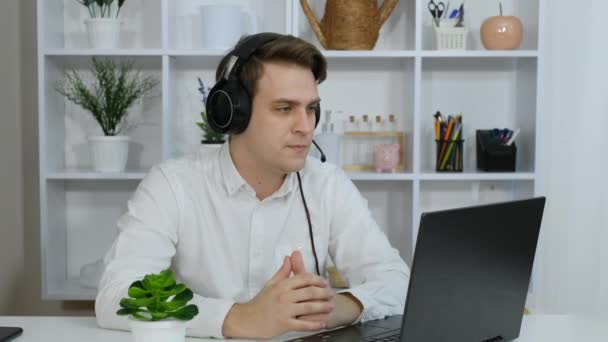 Jovem Senta Com Fones Ouvido Seu Laptop Conversando Com Cliente — Vídeo de Stock