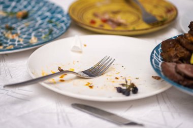 Restoran masasındaki artık yemekler ve kirli tabaklar. Partiden sonra kalan artıklar..