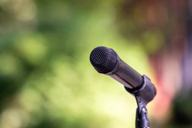 Bulanık tabiatın arka planına karşı bir mikrofonun yakın plan görüntüsü..