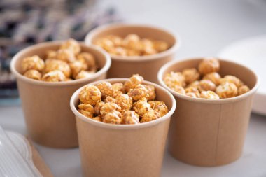 Masanın üzerinde kahverengi kağıt bardaklarda patlamış mısır. Seçici Odaklanma.