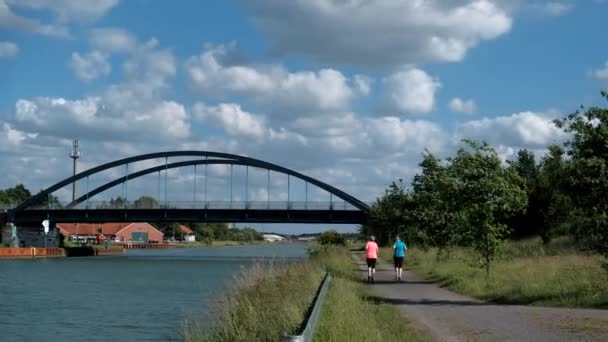 Deux Femmes Font Sport Courir Long Canal Eau Devant Pont — Video