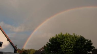 Yağmurdan sonra güzel, büyük bir gökkuşağı. Akşam bir apartmanın zeminine karşı.