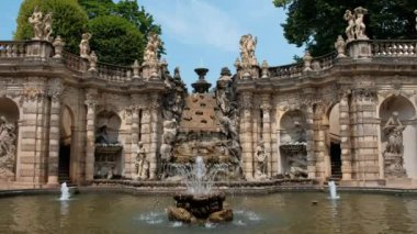 Fountain in the Dresden Zwinger. Baroque architecture with statues. The Nymphenbad . The water flows, flanked by tritons.