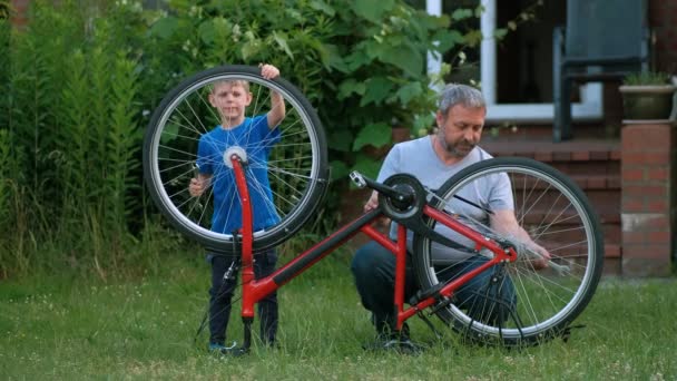 Ein Vater Und Sein Sohn Reparieren Ein Fahrrad Vor Ihrem — Stockvideo