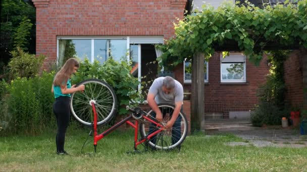 Padre Aiuta Sua Figlia Riparare Sua Bicicletta Fronte Casa Sua — Video Stock