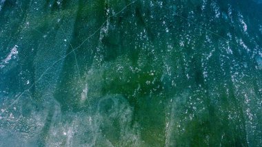 Dağ nehrinde kayaların ve buzların üzerinden akan su