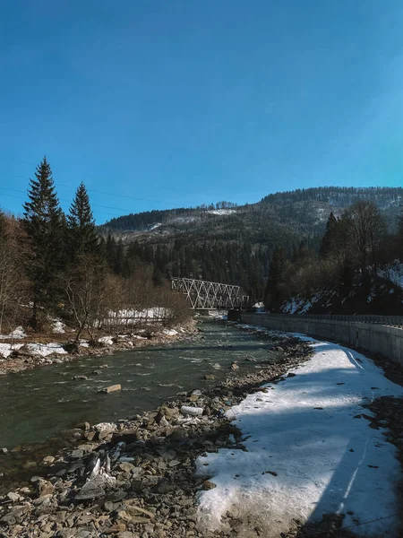 Dağ nehrinde kayaların ve buzların üzerinden akan su