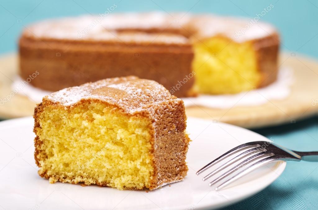 close up of a piece of cake with icing sugar