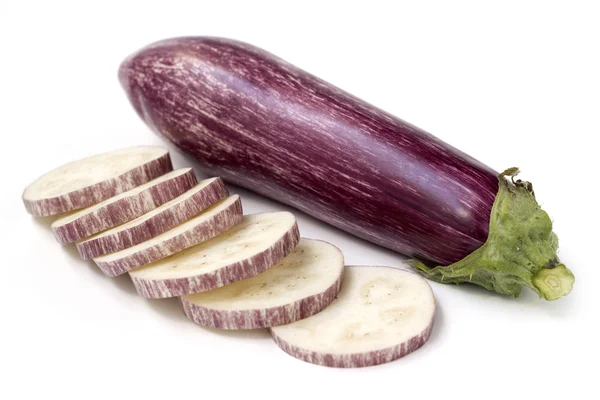 Segmenten van aubergine en hele vruchten op witte achtergrond — Stockfoto