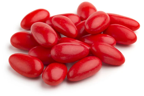 Haufen roter gezuckerter Mandeln auf weißem Hintergrund — Stockfoto