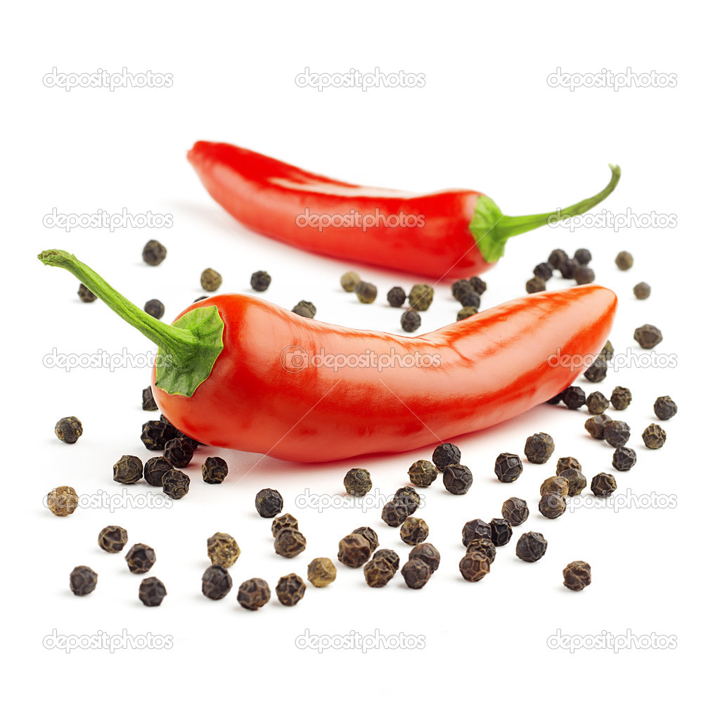 chili peppers and black peppercorns on white background