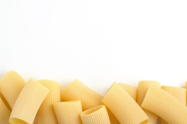 Beyaz bir arka plan kenarına rigatoni yığını