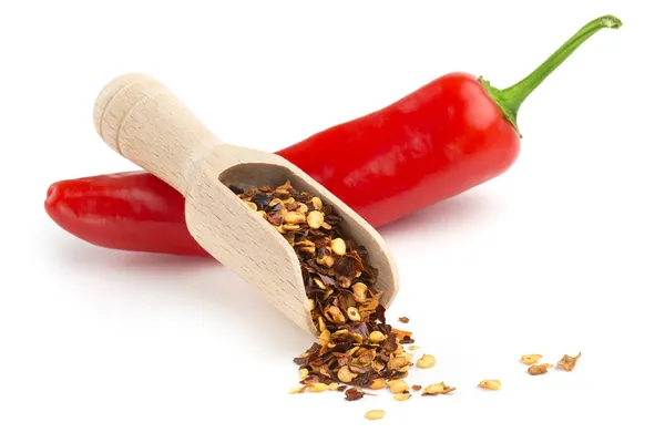 Scoop of ground chili and chili pepper on white background — Stock Photo, Image