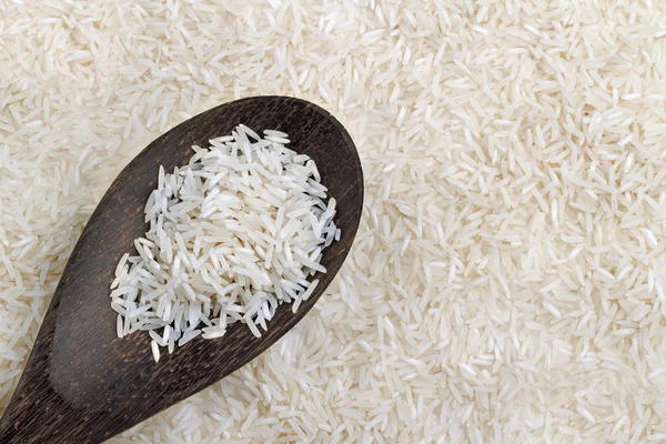 Kochlöffel mit Basmati auf Reishintergrund — Stockfoto