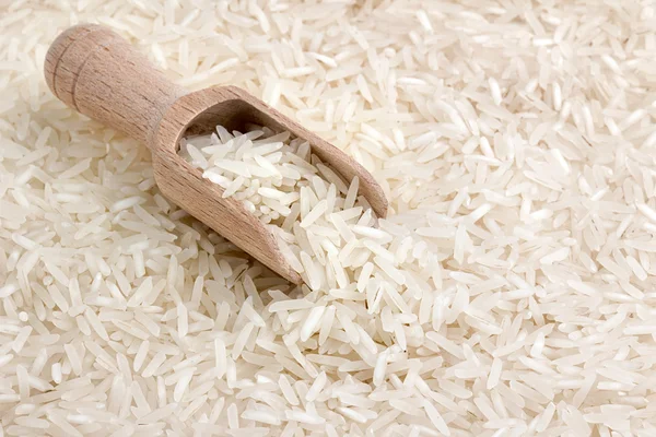 Zblízka rýže basmati s dřevěnou naběračku — Stock fotografie