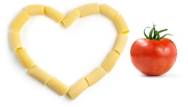 Ригатони и красный помидор на белом фоне — стоковое фото