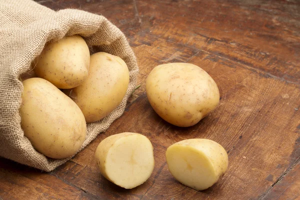 Klettenbeutel mit rohen Kartoffeln und Kartoffelscheiben — Stockfoto