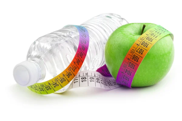 Bottle of water and green apple wrapped by a colorful measuring tape — Stock Photo, Image