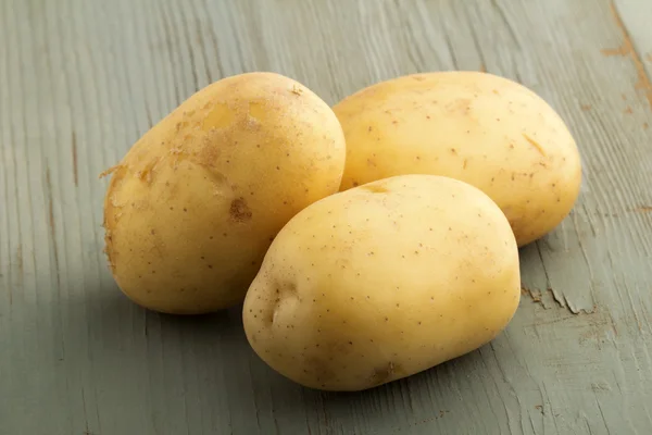 Rohe Kartoffeln isoliert auf Holzboden — Stockfoto