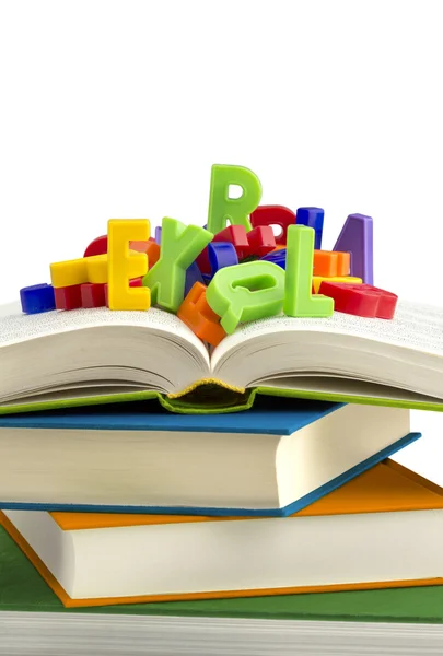 Stack of books with colorful plastic letters on top — Stock Photo, Image