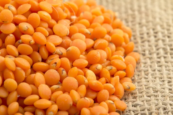 Close up of red lentils on jute background — Stock Photo, Image