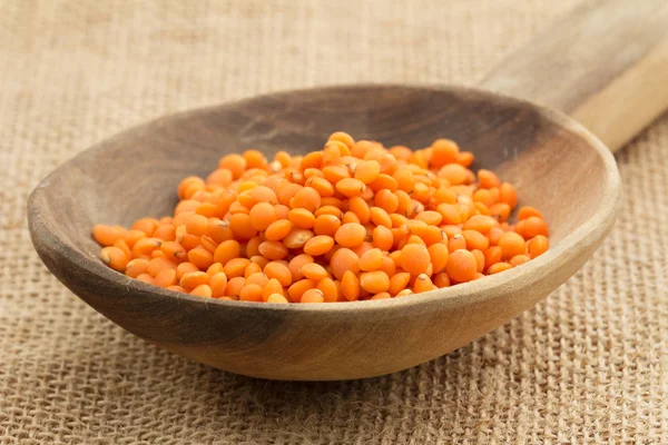 Close up of a wooden spoon with red lentils — Stock Photo, Image