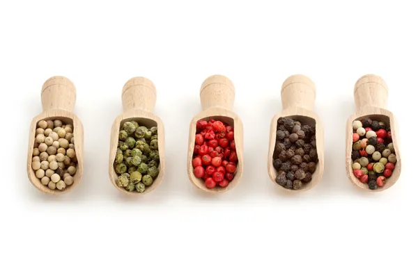 Varieties of peppercorns in wooden scoops on white background — Stock Photo, Image