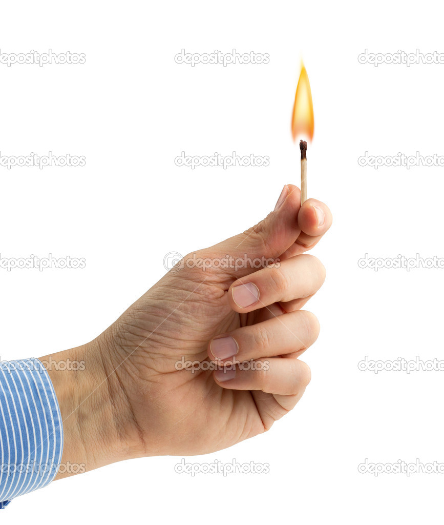 Hand holding a burning matchstick on white background