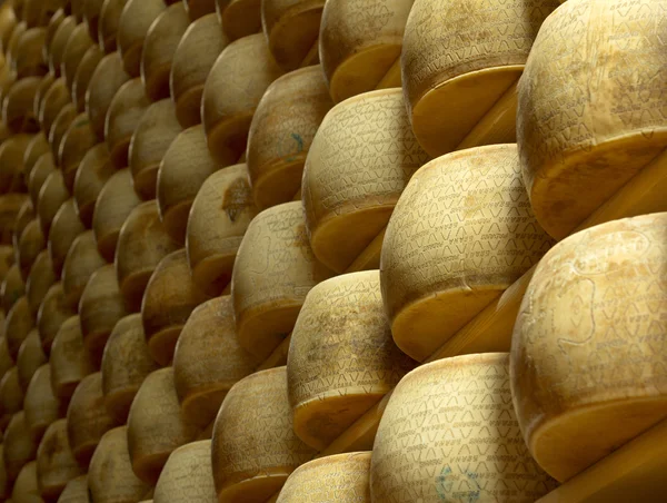 Σωρός των τροχών του τυριού σε μια ωρίμανση αποθήκη — Φωτογραφία Αρχείου