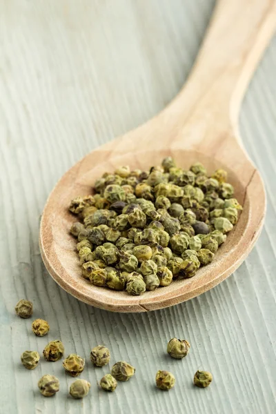 Close up of green pepper in a wooden spoon — Stock Photo, Image