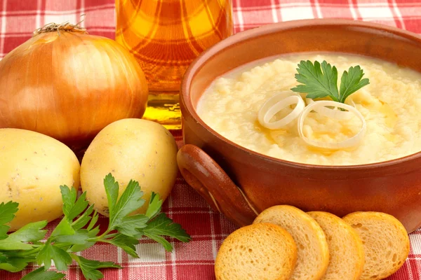 Sopa em uma tigela e ingredientes em uma toalha de mesa — Fotografia de Stock