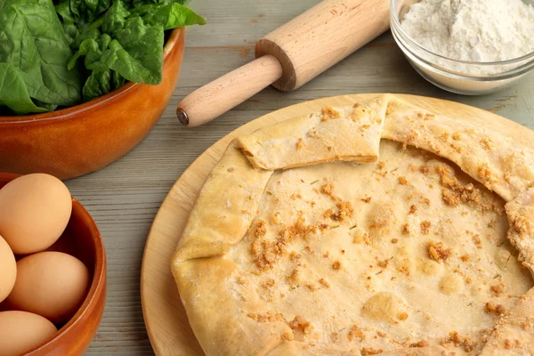 Savory pie and ingredients on a wooden table — Stock Photo, Image