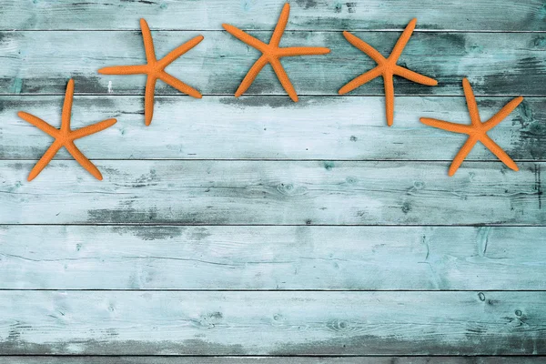 Cinco estrellas de mar sobre un tablero de madera turquesa —  Fotos de Stock