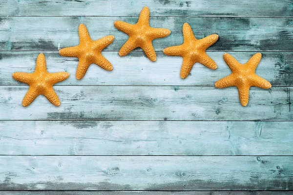 П'ять морських зірок на бірюзовій дерев'яній дошці — стокове фото