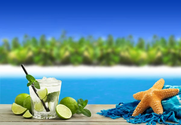 Verse mojito cocktail, zeester en sarong in een tropisch landschap — Stockfoto