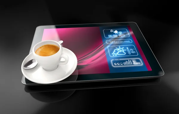 Xícara de café sobre um tablet no fundo preto — Fotografia de Stock