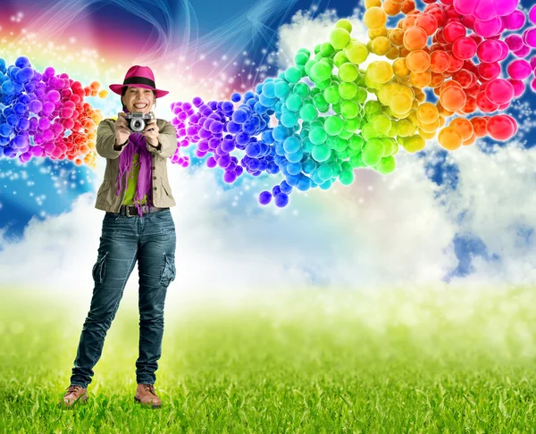 Smiling woman holding a camera in rainbow bubbles