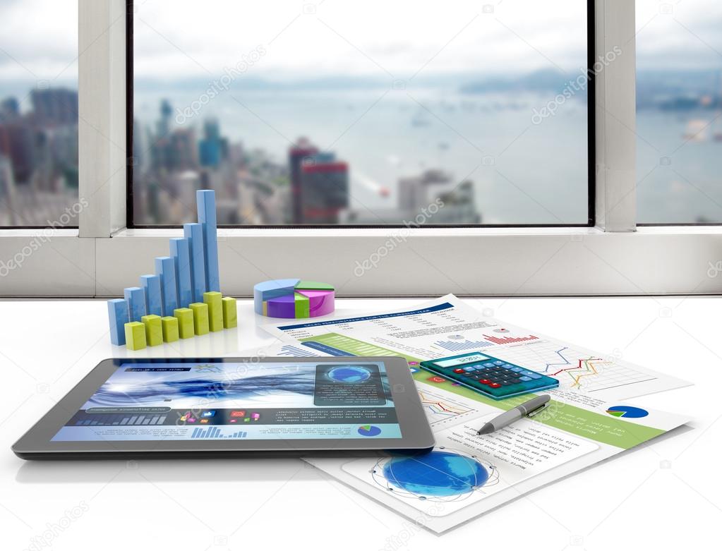 Tablet and financial graphs on a white desk