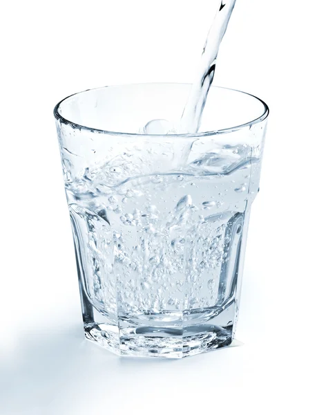 Waterstraal vullen een glas op witte achtergrond — Stockfoto