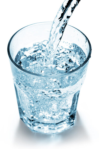 Water jet filling a glass on white background