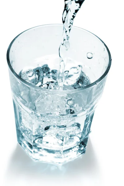 Waterstraal vullen een glas op witte achtergrond — Stockfoto