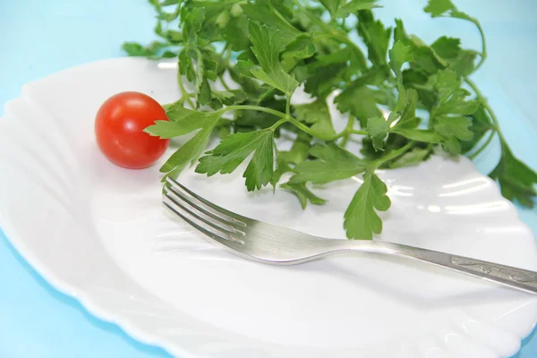 Tomate e erva em uma chapa — Fotografia de Stock