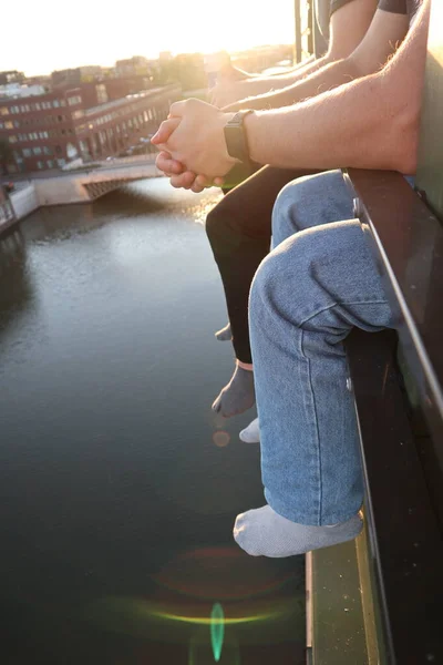 Amsterdam 'da bir kanalın üstündeki pencerede iki arkadaş oturuyor.