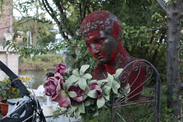 Yunan filozof ve çiçeklerin büstü.